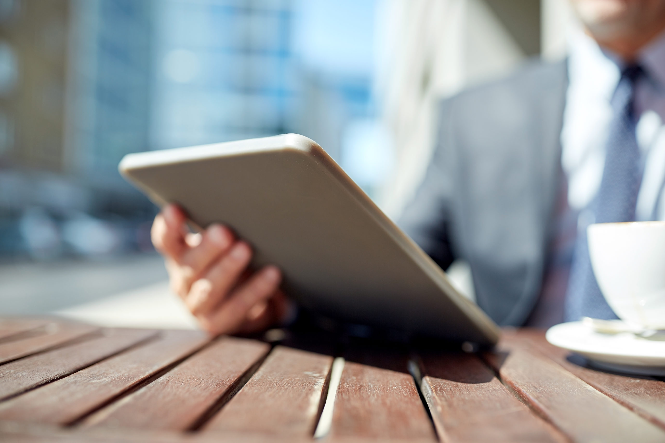 businessman with tablet pc and coffee outdoors